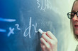 © Tetra Images - Caucasian teacher writing on chalkboard