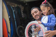 © Tetra Images - Hispanic father teaching daughter to repair bicycle
