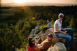 © Tetra Images - Friends resting on rocks in remote area