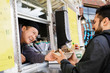 © Tetra Images - Man buying bowl of food at food truck