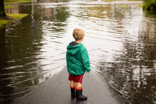 Caucasian Boy Wearing Puddles Near Flood