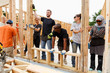 © Tetra Images - Volunteers holding framed wall at construction site