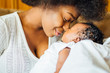 © Westend61 - Close-up of mother rubbing noses with newborn daughter at home