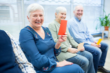 Seniors In Retirement Home Attending Group Therapy Using Colorful Paper Cards