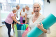 © Westend61 - Happy senior woman holding yoga mat after class