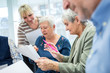 © Westend61 - Seniors in therapy group in retirement home writing down notes on sheets of paper