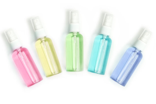 five multi-colored spray bottles made of plastic, with hand sanitizer. White background