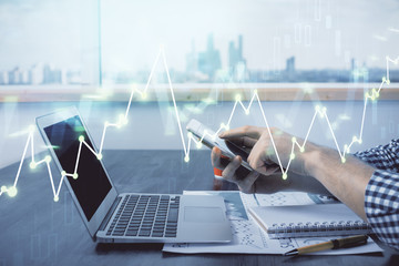 Double exposure of man's hands holding and using a digital device and forex graph drawing. Financial market concept.