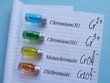 Colored chromium solutions in glass reagent bottles. Chromium-based solutions with chemical formulas of chromium complex ions in different oxidation states. Yellow, orange, blue, green chromium liquid