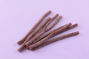 Sticker - Sour blueberry fruit flavored gummy candy sticks on lavender background