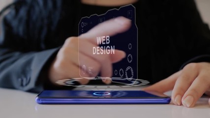 Female hand interacts HUD hologram with text Web Design. Woman in black uses conceptual holographic technology of the future on the screen of a smartphone lying on a table