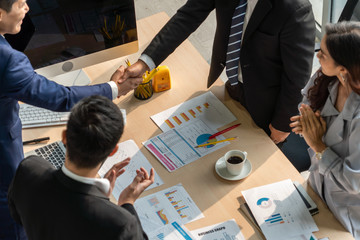 Group business people handshake at meeting table in office together with confident shot from top view . Young businessman and businesswoman workers express agreement of investment deal.