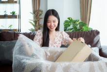 Asian Woman Unpack Packaging After Online Shopping From Discount Store