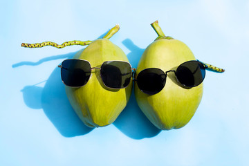 Canvas Print - Coconuts with sunglasses on blue background. Copy space