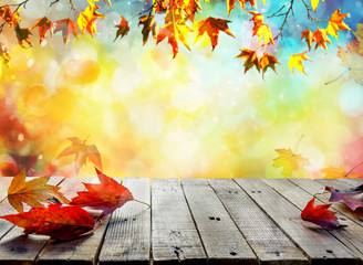 Wooden table with orange leaves autumn background