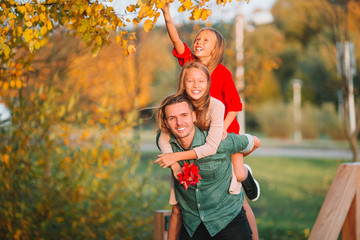 Family of dad and kids on beautiful autumn day in the park