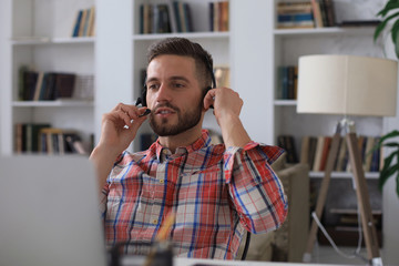 Wall Mural - Smiling young business man having video call at home office.