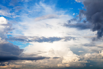 Wall Mural - sun blocked by rain clouds in blue sky in summer evening