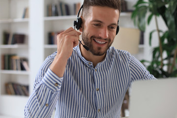 Wall Mural - Smiling young business man having video call in office.