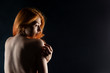 © Alexandr - Young red-haired woman with naked back. On dark background.
