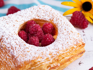 Yummy freshly tart cake puff pastry with raspberries, close up, custard