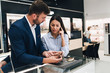 © Dusko - Beautiful couple enjoying in shopping at modern jewelry store. Close up shot of human hand holding expensive watch.