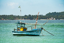 Small Blue Fishing Boat Bobbing In Harbour 