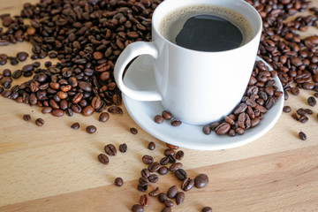 Wall Mural - A cup of black coffee, with coffee grains, natural light on wooden table