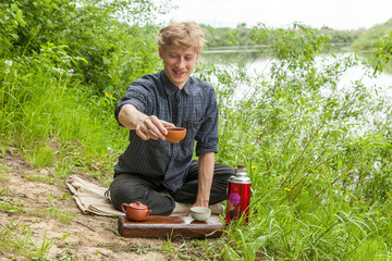 Blonde guy giving you up of chinese tea in spring park