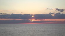 Sunset Beaming Through Clouds Sun Rays Pink Purple Yellow Gold Glimmer Over Waves Wide Static Lake Huron Ontario 