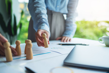 A group of business team brainstorming and planning strategy together with.wooden people in a meeting