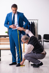 Young businessman visiting old male tailor