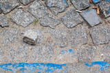 Fototapeta Kamienie - Zbliżenie na fragment brukowanej, brudnej ulicy.