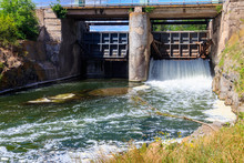 Flowing Water With Water Spray From The Open Sluice Gates Of A Small Dam