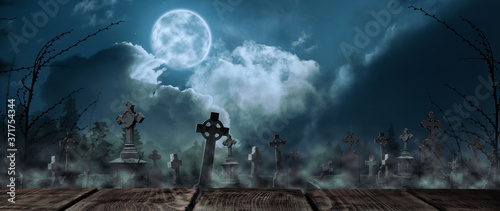 Cuadros en Lienzo Wooden surface and misty graveyard with old creepy headstones under full moon