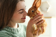 © New Africa - Young woman with adorable rabbit indoors, closeup. Lovely pet