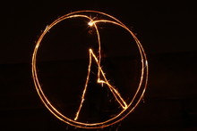 Light Trails On A Dark Background, Peace Sign  Made With Fie Sticks.