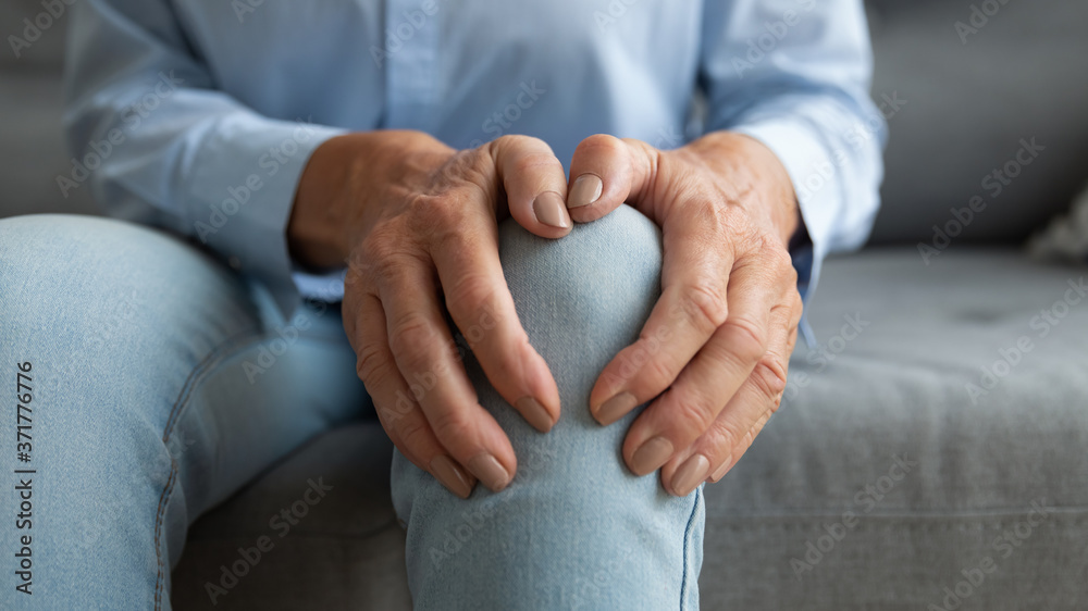Close up mature old woman touching knee joint, having painful feelings. Unhealthy middle aged senior female retiree suffering from arthritis, bones disease osteoporosis or inflammation processes. - obrazy, fototapety, plakaty 