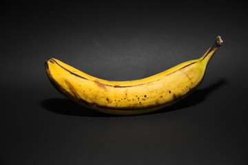 isolated ripe yellow banana in front of a black background