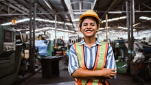 Attractive Young African Woman Smiling And Working Engineering In Industry.Portrait Of Young Female Worker In The Factory.Work At The Heavy Industry Manufacturing Facility Concept.