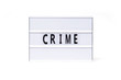  Crime. Text on a vintage lightbox display placed on a white table on a light background.    
