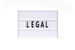  Legal. text on a vintage lightbox display placed on a white table on a light background.    