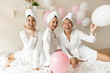 Well-groomed girls gather together celebrating bridal shower, wearing bath robe after spa beauty procedures with head wrapped in towel enjoy fun, body pamper everyday care nourishing moisturizing care