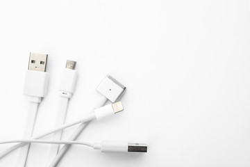 Charge cables on white background, top view. Modern technology