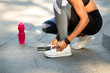 © Prostock-studio - Closeup of black athletic girl tying shoelaces before jogging