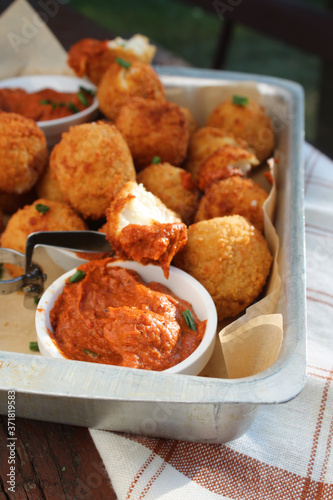 Cheese balls with tomato sauce. Fried snack starter meal. Party food © Irati