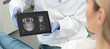 © Proxima Studio - Dentist showing teeth x-ray on tablet screen