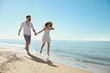 © New Africa - Happy young couple running on beach near sea. Honeymoon trip