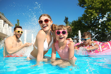 Canvas Print - Happy family having fun in swimming pool