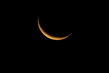 Waning Crescent Moon Rising In The Early Dawn.